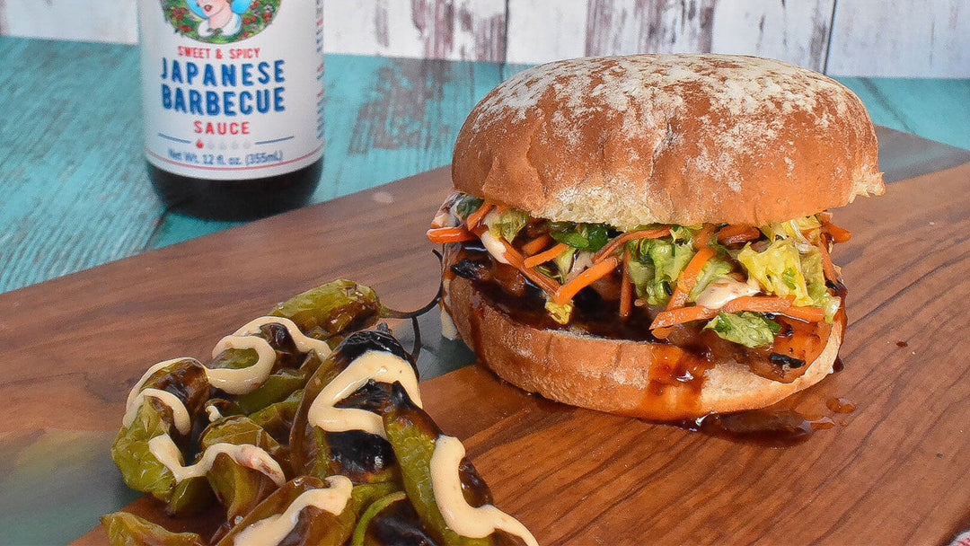 Japanese BBQ chicken sandwich with Asian slaw on artisan bun, served with grilled peppers and Japanese barbecue sauce bottle