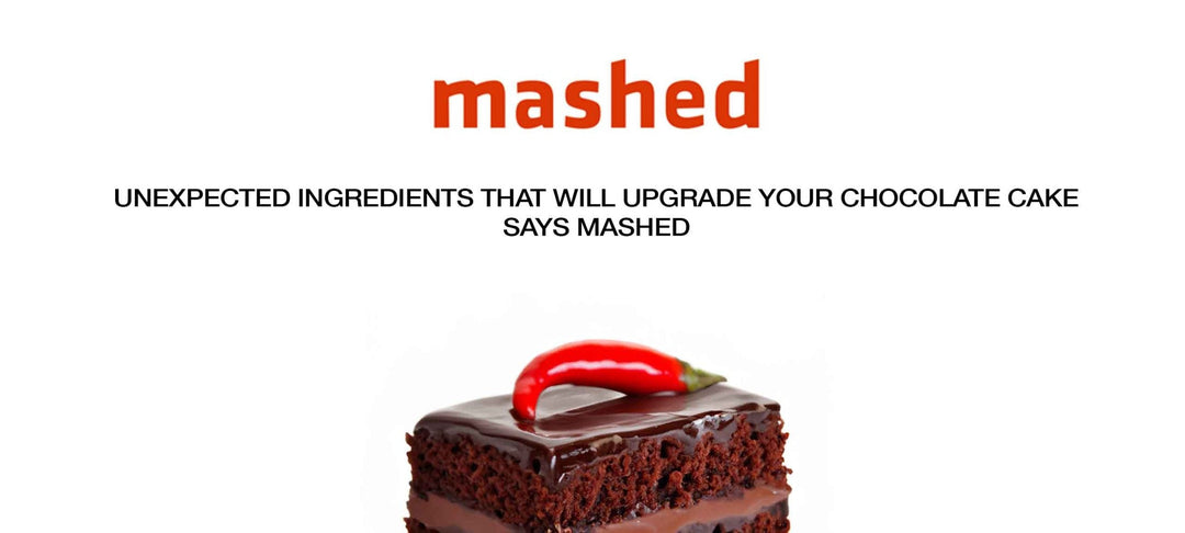 Chocolate cake slice with dark frosting topped with a red chili pepper, illustrating unexpected ingredients for cake recipes